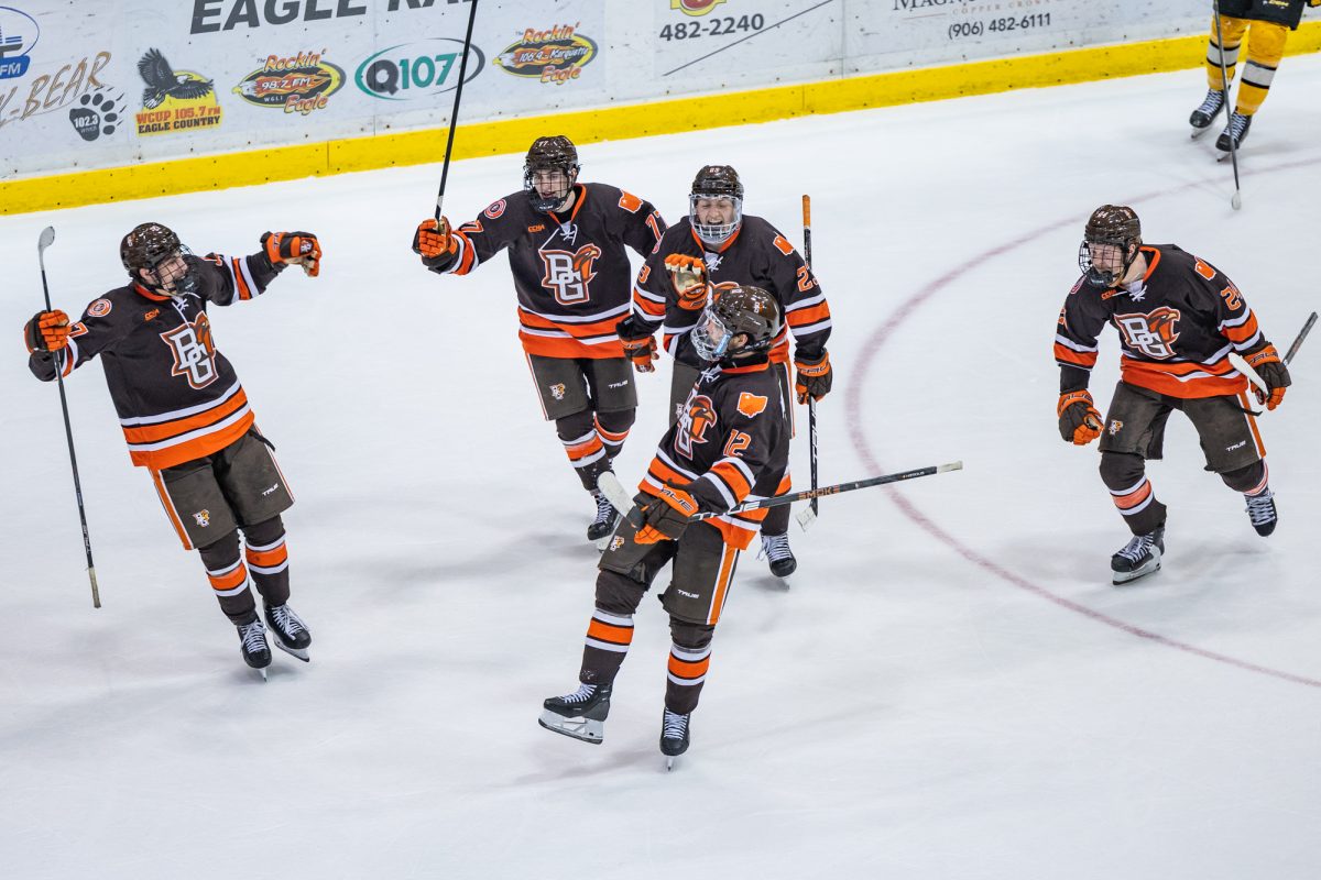 Houghton, MI - Falcons senior forward Jackson Niedermayer gets chased down by his teammates after drilling a goal to clinch home ice in the CCHA playoff, during a game between the Bowling Green Falcons and the Michigan Tech Huskies at the John MacInnes Student Ice Arena, in Houghton, Michigan.