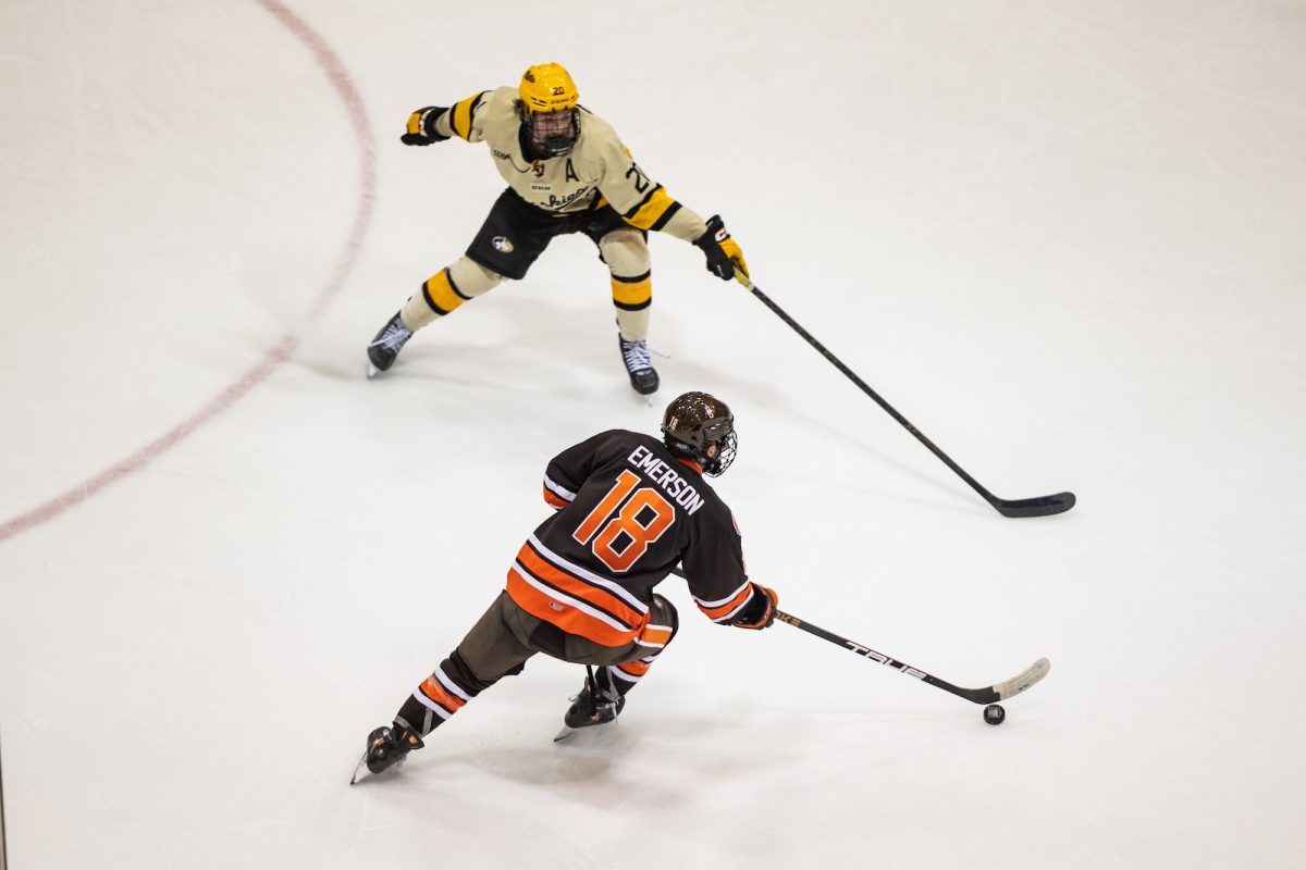 Houghton, MI - Falcons senior forward Quinn Emerson (18) looks to skate past Huskies senior defenseman Joe Prouty (20) during a Mason Cup playoff game between the Bowling Green Falcons and the Michigan Tech Huskies at the John MacInnes Student Ice Arena, in Houghton, Michigan.