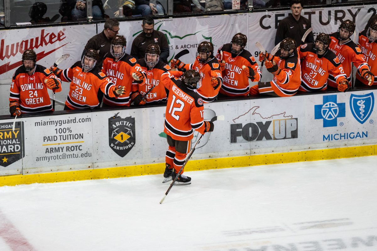 Houghton, MI - Falcons senior forward Jackson Niedermayer (12) skates down the bench after scoring during a Mason Cup playoff game between the Bowling Green Falcons and the Michigan Tech Huskies at the John MacInnes Student Ice Arena, in Houghton, Michigan.