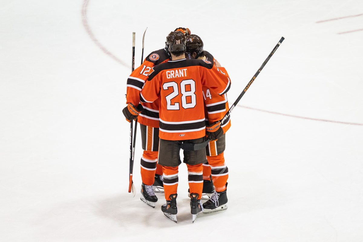 Houghton, MI - Falcons senior forward Jackson Niedermayer (12), senior forward Jaden Grant (28) and senior defenseman Dalton Norris (14) embrace on the ice after a Mason Cup playoff game between the Bowling Green Falcons and the Michigan Tech Huskies at the John MacInnes Student Ice Arena, in Houghton, Michigan.