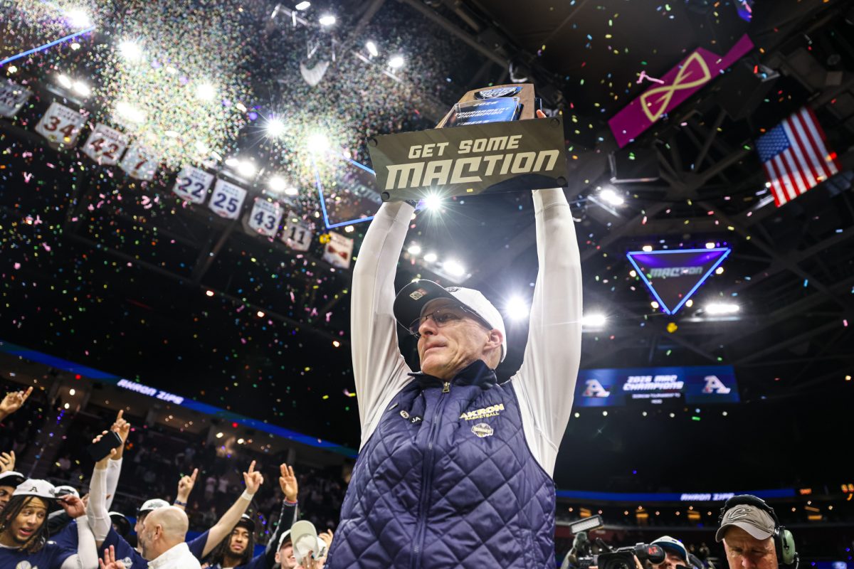 Cleveland, OH - Zips head coach John Groce holds up the MAC Championship trophy after defeating the Rockets in the MAC Championship game at Rocket Arena in Cleveland, Ohio.
